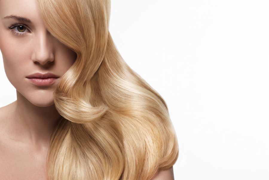 Model with long, glossy blonde hair styled at Defusion Hair Salon